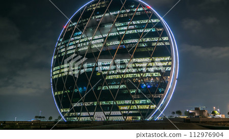 The Aldar headquarters building night timelapse is the first circular building of its kind in the Middle East in Abu Dhabi, UAE 112976904