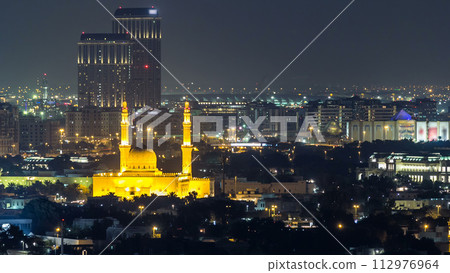 Dubai skyline with The Jumeirah Mosque illuminated at night timelapse. Dubai, United Arab Emirates Dubai skyline with The Jumeirah Mosque illuminated at night timelapse. Dubai, United Arab Emirates 112976964