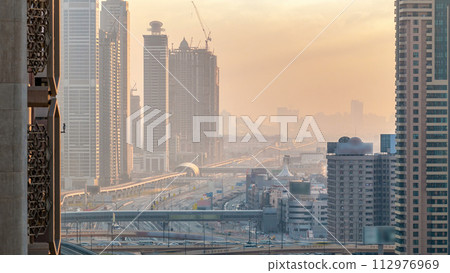 Downtown Dubai towers in the evening timelapse. Aerial view of Sheikh Zayed road with skyscrapers at sunset. 112976969