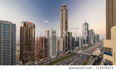 Downtown Dubai towers day to night timelapse. Aerial view of Sheikh Zayed road with skyscrapers after sunset. 112976974