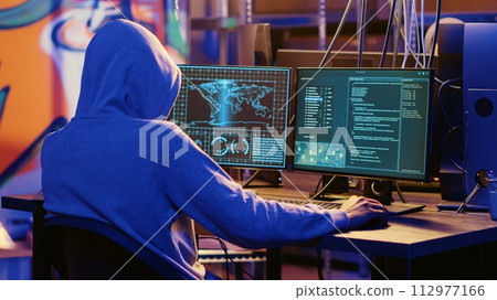Hooded spy in underground hideout trying to steal valuable data by targeting governmental websites with weak security. Espionage specialist doing cyber attacks to gain access to sensitive info 112977166