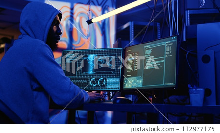 Hacker with malicious intent doing data breaches and financial theft in dark bunker. Cybercriminal stealing users bank account credentials, targeting low security passwords 112977175