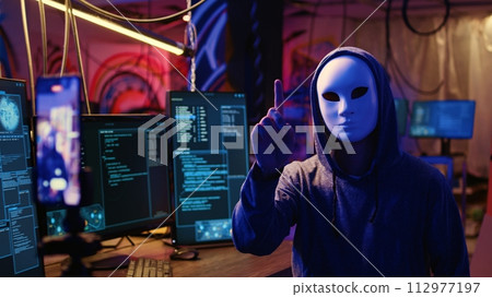 Masked hackers filming video threatening to not stop coordinating DDoS attack on website and send large amounts of traffic from multiple sources to overwhelm it unless their demands are not met Masked hackers filming video threatening to not stop coordinating DDoS attack on website and send large amounts of traffic from multiple sources to overwhelm it unless their demands are not met 112977197
