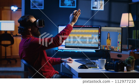 Photo editor using high tech VR goggles to look at editorial pictures taken with professional camera for fashion magazine. Freelancer browsing images using virtual reality headset technology 112977210