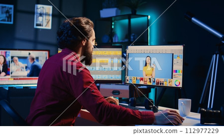 Photo editor color correcting photographs in creative studio using graphic tablet, jib down shot. Photographer selecting best pictures for editorial content using stylus on touchscreen device 112977229