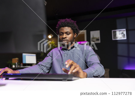 Player using keyboard and mouse to play first person shooter videogame on PC, enjoying leisure time. Man in living room using high tech computer peripherals to destroy enemies Player using keyboard and mouse to play first person shooter videogame on PC, enjoying leisure time. Man in living room using high tech computer peripherals to destroy enemies 112977278