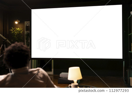 Person using isolated screen large smart TV to binge series on subscription based streaming services, having fun. BIPOC man relaxing, enjoying VOD shows on mockup television display Person using isolated screen large smart TV to binge series on subscription based streaming services, having fun. BIPOC man relaxing, enjoying VOD shows on mockup television display 112977293