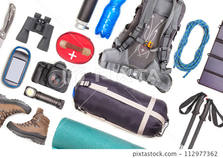 Set of tourist trekking items on white background. Top view of accessories for travel 112977362