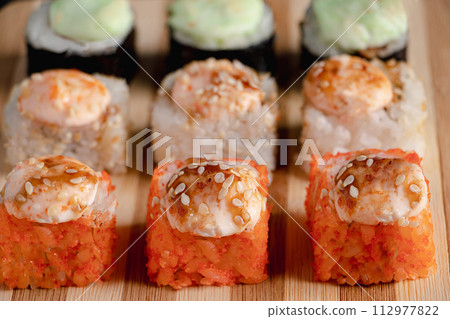 Set of sushi rolls on bamboo serving tray. Uramaki and futomaki roll Set of sushi rolls on bamboo serving tray. Uramaki and futomaki roll 112977822