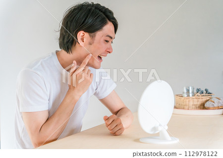 Young man concerned about cavities, orthodontics, periodontal disease, and teeth (toothache) 112978122