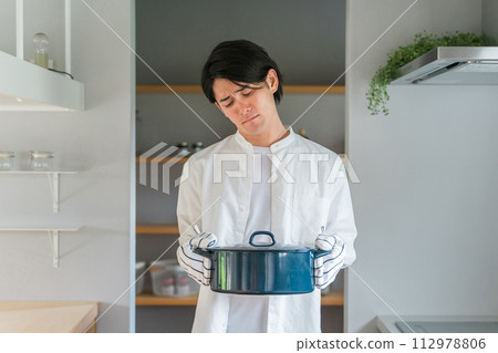 廚房裡拿著鍋子的憂心忡忡的男人,不擅長做飯的丈夫,家庭主婦,做飯的男孩 廚房裡拿著鍋子的憂心忡忡的男人,不擅長做飯的丈夫,家庭主婦,做飯的男孩 112978806