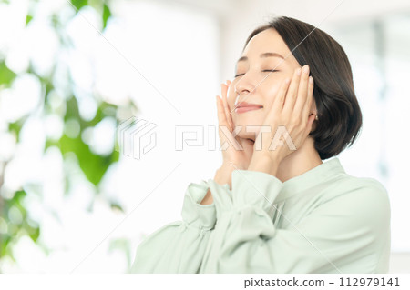 A middle-aged woman feels moisturized 112979141