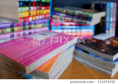 Comic books stacked on the table 112979392