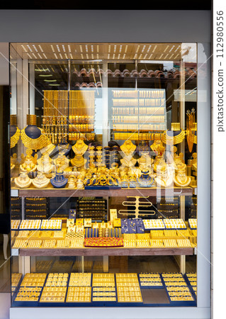 Gold jewelry in glass windows of street shops in Konya 112980556