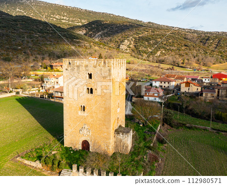 Medieval high multi-storey Valcedoceda Tower among hills covered with greenery and forests, Spain Medieval high multi-storey Valcedoceda Tower among hills covered with greenery and forests, Spain 112980571