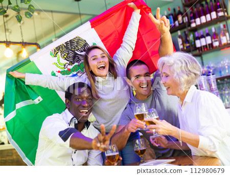 Joyful fans of the Mexican team celebrating the victory in night bar 112980679