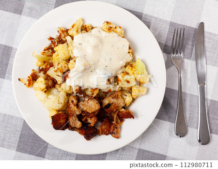 Cauliflower with lard served on plate 112980711