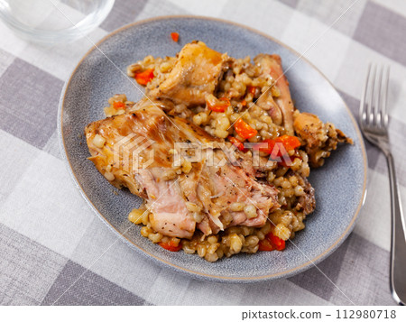 Lunch is served on plate - baked pieces of young rabbit and pearl barley Lunch is served on plate - baked pieces of young rabbit and pearl barley 112980718
