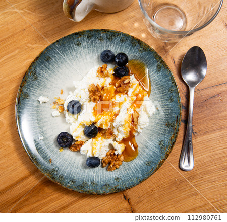 Farm cottage cheese filled with large amount of honey with walnut and blueberry. Farm cottage cheese filled with large amount of honey with walnut and blueberry. 112980761
