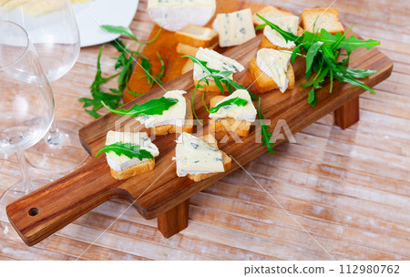 Blue cheese served with toast and arugula 112980762