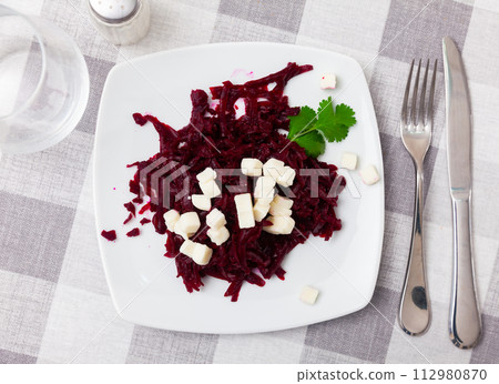 Salad with chopped beetroot and farmer cheese decorated with parsley 112980870
