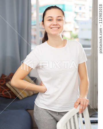 Smiling young housewife posing at home 112981018