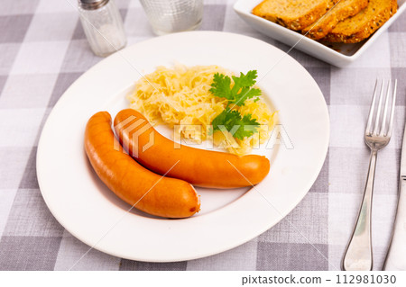 Fried sausages served with pickled cabbage Fried sausages served with pickled cabbage 112981030