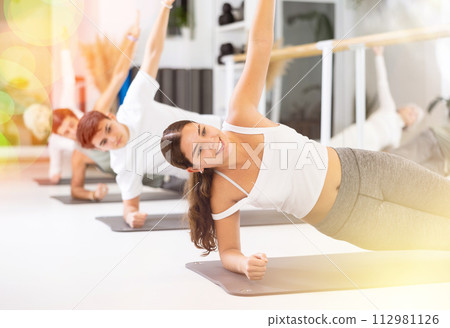 Young woman practicing pilates in gym room 112981126