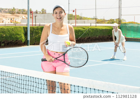 Portrait of young woman tennis player with tennis racket and balls in her hands 112981128