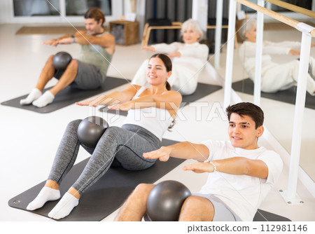 Group of different people doing exercises with ball 112981146