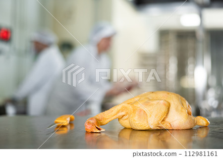 Raw dressed chicken lying on cutting table of butchers shop Raw dressed chicken lying on cutting table of butchers shop 112981161