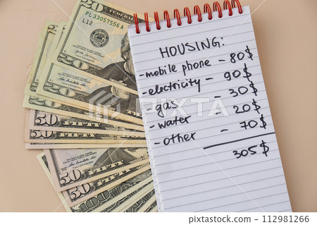 Counting expenses bills on housing electricity, gas, water. Banknotes of dollar cash around. High prices for energy inflation crisis. Cut back on spending Counting expenses bills on housing electricity, gas, water. Banknotes of dollar cash around. High prices for energy inflation crisis. Cut back on spending 112981266