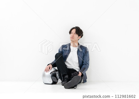 戴著頭盔坐著的男騎手 112981602