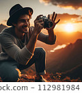 A man taking a photo and the sunset 112981984
