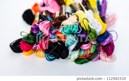 Many skeins of mouline thread for embroidery on a row in circle on black background Many skeins of mouline thread for embroidery on a row in circle on black background 112982520