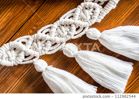 curtain tieback in boho style on wooden shelf curtain tieback in boho style on wooden shelf 112982544