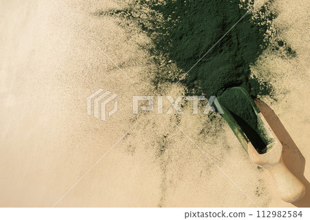 Natural organic green spirulina algae powder in wooden spoon on neutral background. Chlorella seaweed vegan superfood supplement source and detox. Copy space Healthy nutritional antioxidant Natural organic green spirulina algae powder in wooden spoon on neutral background. Chlorella seaweed vegan superfood supplement source and detox. Copy space Healthy nutritional antioxidant 112982584