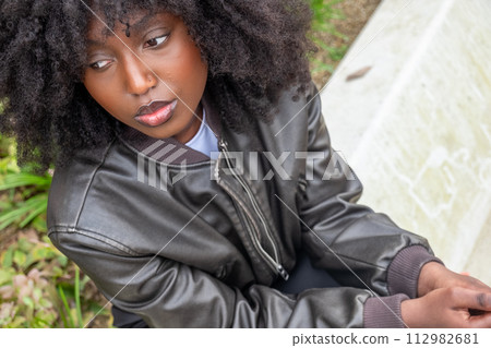 Pensive African American Woman with Natural Hair Outdoors Pensive African American Woman with Natural Hair Outdoors 112982681