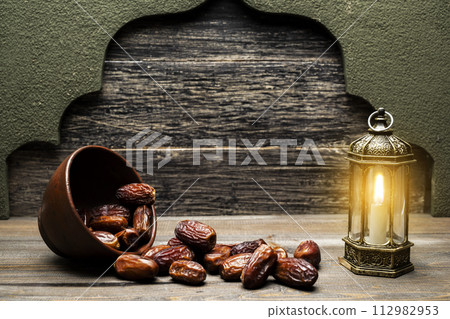 Arabic lantern and dried dates fruit for iftar on Ramadan in the bowl Arabic lantern and dried dates fruit for iftar on Ramadan in the bowl 112982953