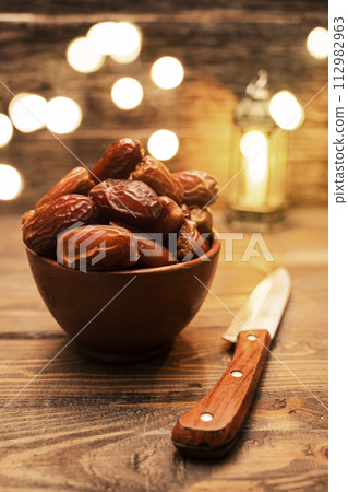 Image of tasty dried dates fruits and knives with arabian light background. The Muslim feast of the holy month of Ramadan Kareem. Image of tasty dried dates fruits and knives with arabian light background. The Muslim feast of the holy month of Ramadan Kareem. 112982963