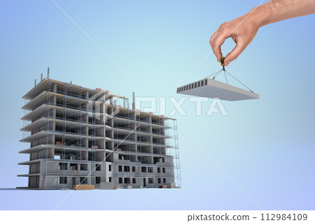 Hand placing the last piece on a construction site 112984109