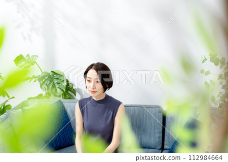 A smiling woman sitting on the sofa 112984664