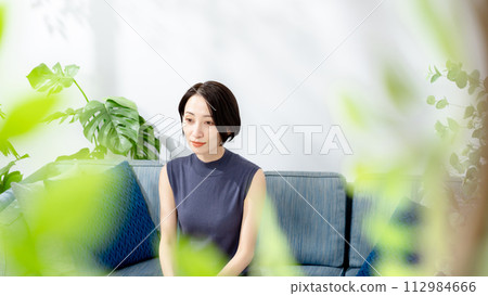 A smiling woman sitting on the sofa 112984666