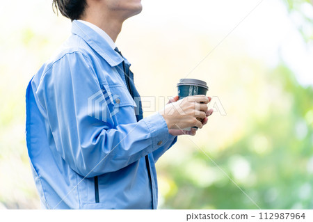 A man wearing work clothes worries about his hands 112987964