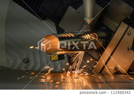 Close up scene the fiber laser cutting machine cut the stainless steel tube and sparkling light. 112988342