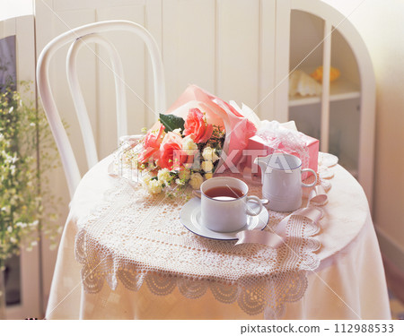White tea cup and tea set and bouquet of flowers White tea cup and tea set and bouquet of flowers 112988533