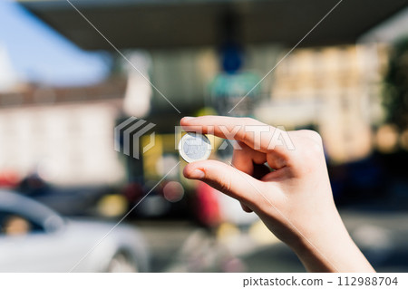 Euro coin and refueling of a car at a gas station in city, expensive fuel oil Euro coin and refueling of a car at a gas station in city, expensive fuel oil 112988704