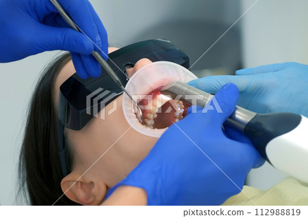 Dentist is doing intraoral scanning for woman before installing ceramic crowns. 112988819