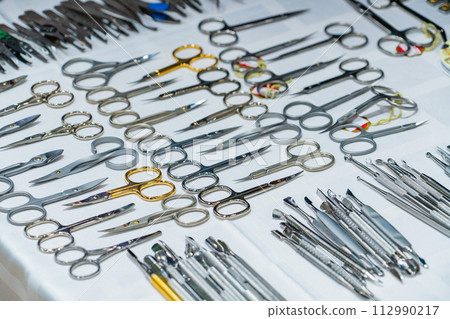 Set of many different scissors for manicure. Metal scissors on a white background. Close-up Set of many different scissors for manicure. Metal scissors on a white background. Close-up 112990217