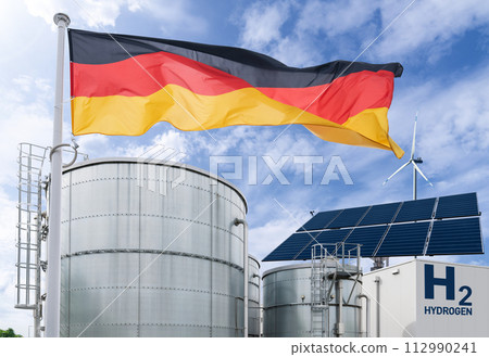 German flag on a background of green hydrogen factory. Concept. German flag on a background of green hydrogen factory. Concept. 112990241